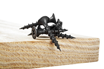 Screws on wooden plank on a white background