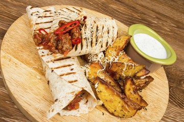  Pancakes with meat and sauce on wooden table.