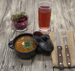 Beet  salad and tomato, red pepper soup, sauce with olive oil, rosemary and smoked paprika with fork and a glass of juice and knife on a wooden background