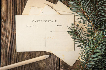 Postcards with fir tree and pencil on the wooden table