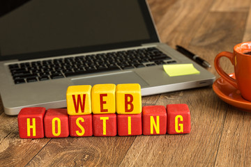 Web Hosting written on a wooden cube in a office desk