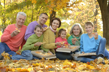 Family eating pizza in  park