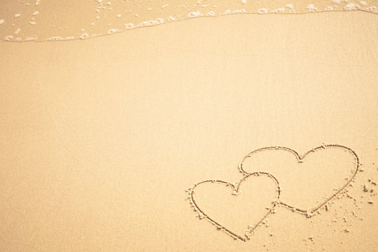 two hearts written on the beach