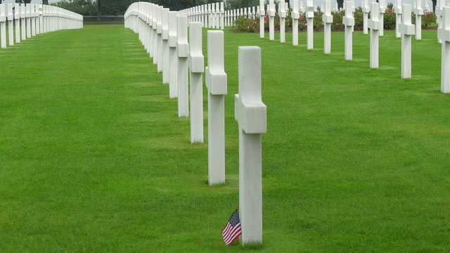 One of the cross in the cemetery with an American flaglet found on the bottom of the tomb