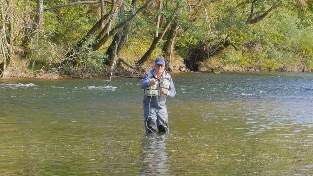 Fly- fisherman fishing in river