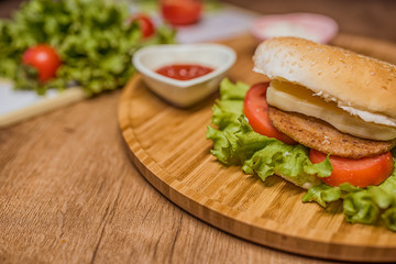 hamburger with cutlet grilled on a wooden surface