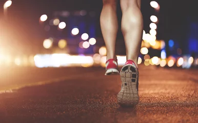 Selbstklebende Fototapete Joggen Weibliche Beine, die durch die städtische Umgebung laufen
