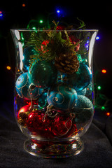 Decorative vase filled with shiny Christmas ornaments.