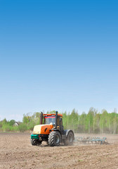 Obraz premium Tractor cultivating field
