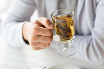 close up of man drinking tea at home or cafe