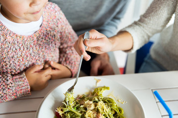 close up of family having dinner at restaurant