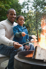 Naklejka premium Father and son toasting marshmallows