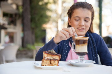 Girl in the street drink a capuccino