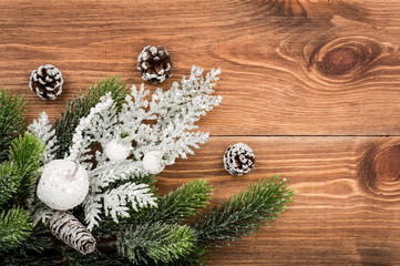 Christmas decoration - silver and green coniferous branches on the wooden background.