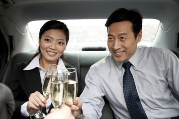 business people toasting in car