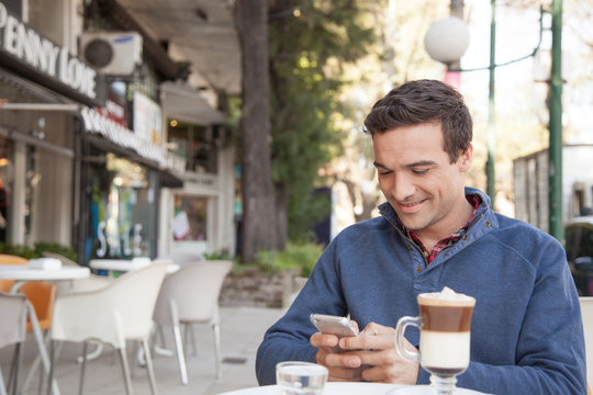 Man sitting in the street using the cellphone