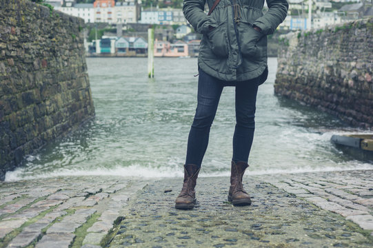 Feet and legs of person by water in harbour