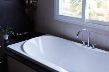 white bathtub in luxury bathroom dark brown tone style