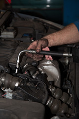 Obraz na płótnie Canvas Hands of car mechanic in auto repair service.