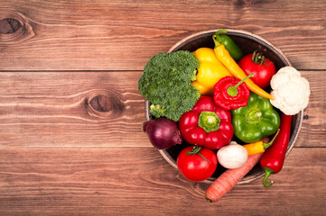 Fresh vegetables on the wooden tray on the rustic background.