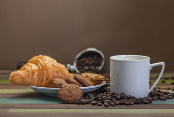 White coffee cup with cookies and beans background