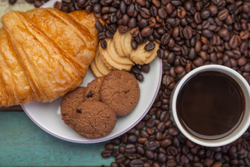 Close up cup of coffee with cookies and beans background