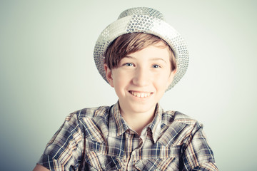 smiling little boy with party hat on gray background