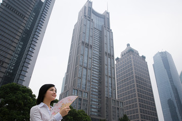 Fototapeta na wymiar Chinese woman near skyscrapers