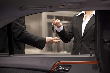 Car dealer giving buyer keys