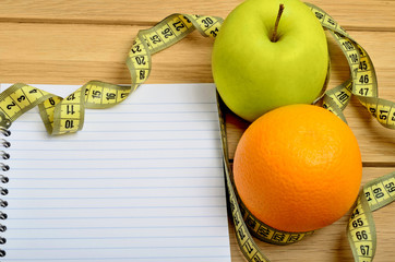 Notebook with apple and orange fruit