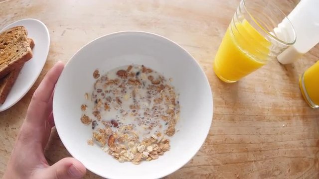 Point of view of man eating cereal and drinking juice