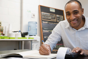 Man doing accounts in cafe