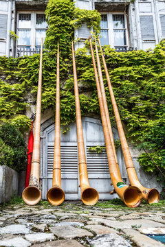 Five alphorns are leaning against the house in the Gruyere village, Switzerland