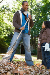 Father and daughter raking leaves