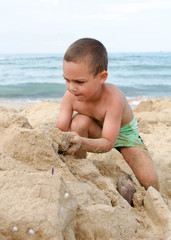 Child playing with sand on beach