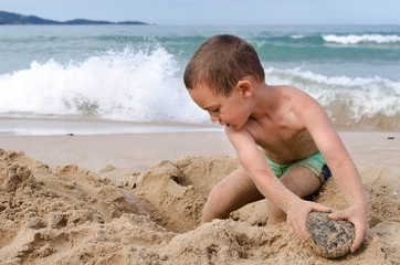 Child playing with sand on beach