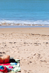MUJER LEYENDO EN LA PLAYA TUMBADA AL SOL