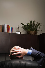Businessman relaxing with hands behind his head