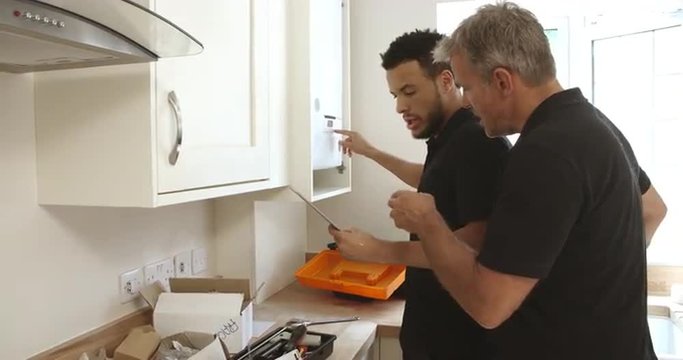 Engineer teaching apprentice how to program domestic boiler