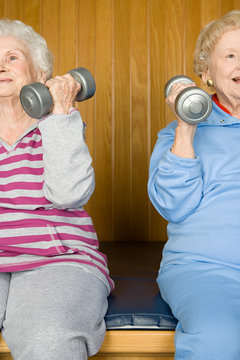 Two senior women lifting dumbbells