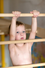 Boy hanging on the ladder.