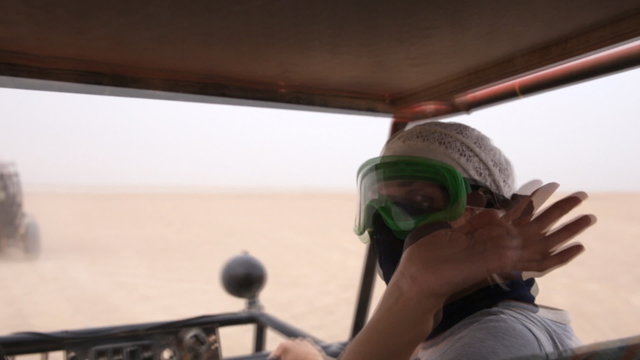 Girl says hi from traveling through the desert buggy