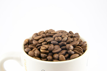 Cup full of coffee beans isolated