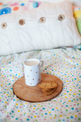 Coffee and cookies on a bed with pillows