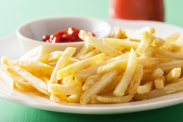 french fries with ketchup over green background