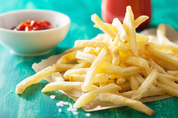 french fries with ketchup over green background