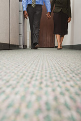 Two colleagues walking holding hands