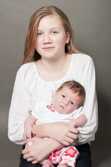 Cute young girl holding a new born baby