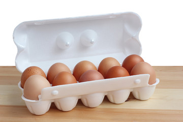 Ten brown eggs in packing on a table, isolate.