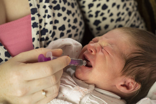 mum giving baby medicine